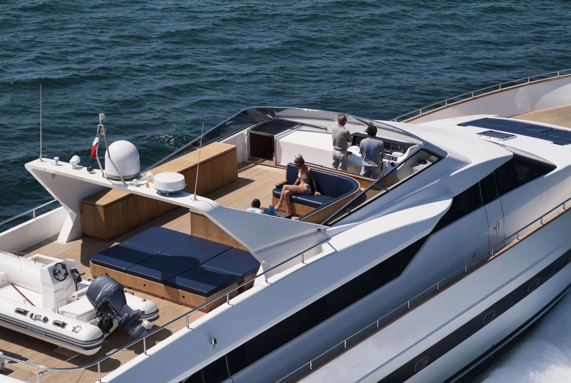 Guests relaxing on the upper deck of a superyacht at sea